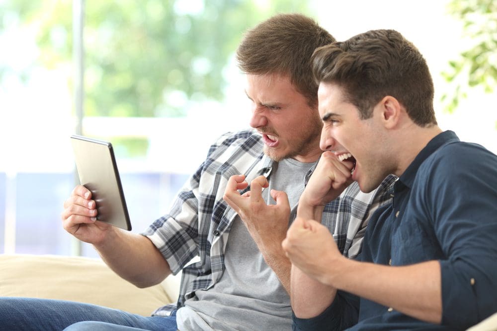 Angry friends watching media in a tablet AI Management